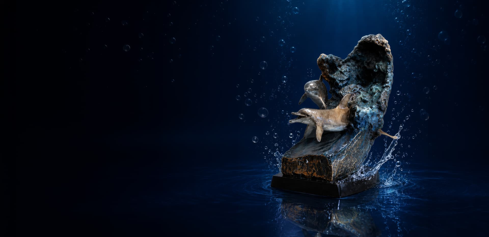 Bronze sea turtle sculpture against a deep blue underwater backdrop with rising bubbles